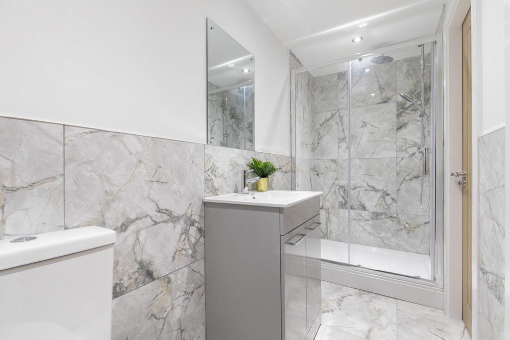 Modern bathroom with marble-effect tiles, a wal...