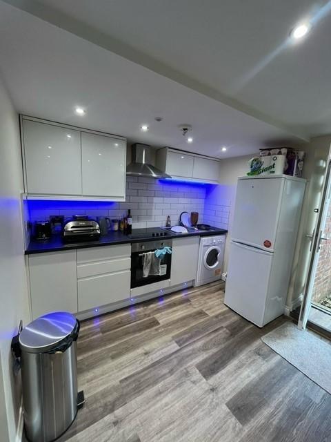 Contemporary fitted kitchen with glossy white c...