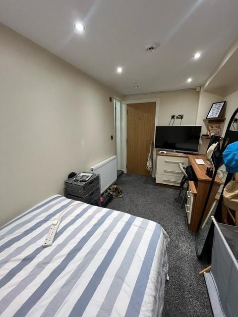 Cozy furnished bedroom with a striped bed, beds...