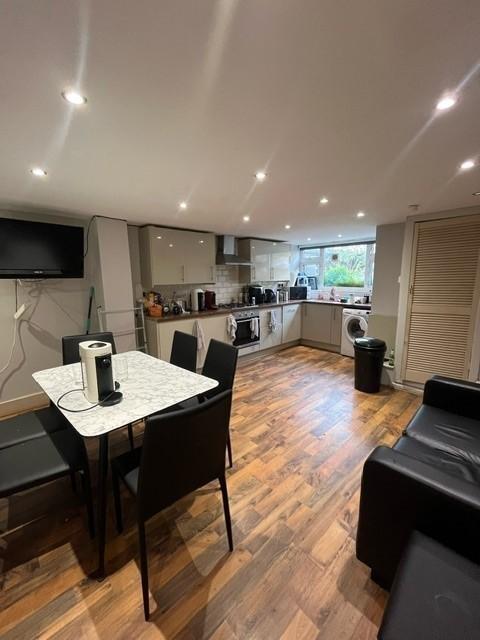 Modern open-plan kitchen with wood-effect floor...
