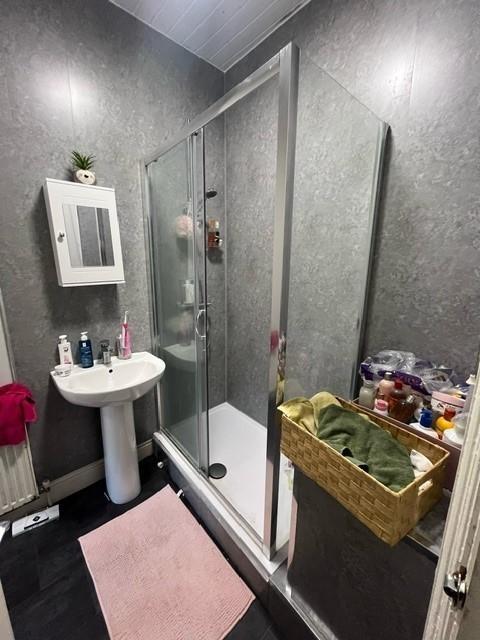 Modern bathroom with a glass-enclosed shower, p...
