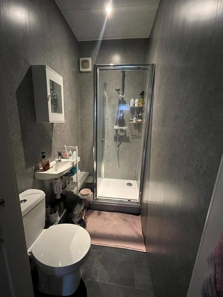 Modern, compact bathroom with a glass-enclosed ...