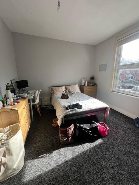 Bright, simply furnished bedroom with a double ...
