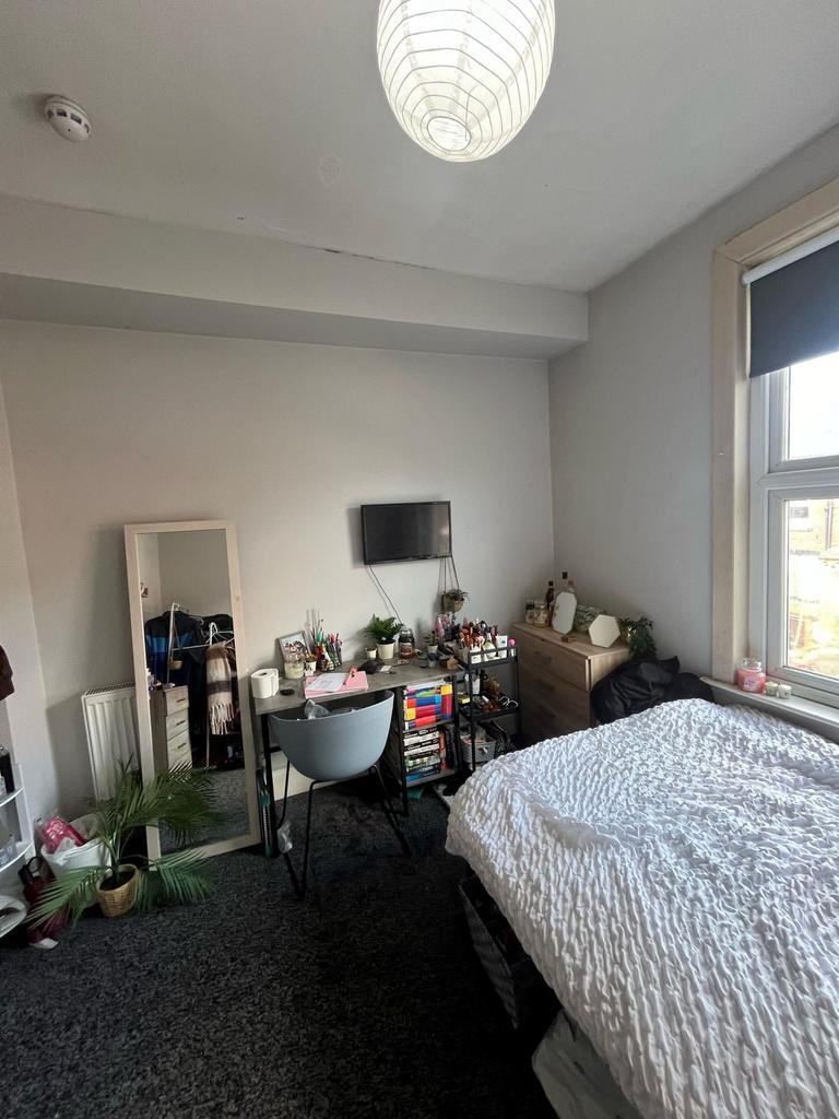 Bright, neatly arranged double bedroom with a c...
