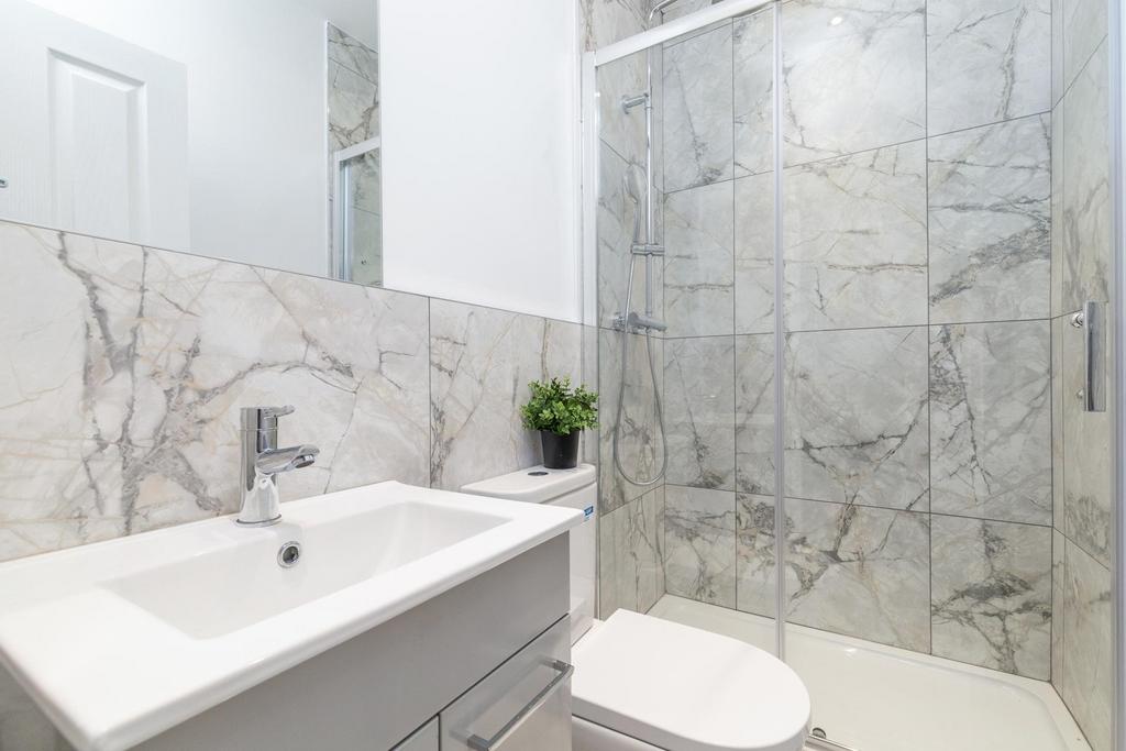 Bright, modern bathroom with a walk-in glass sh...