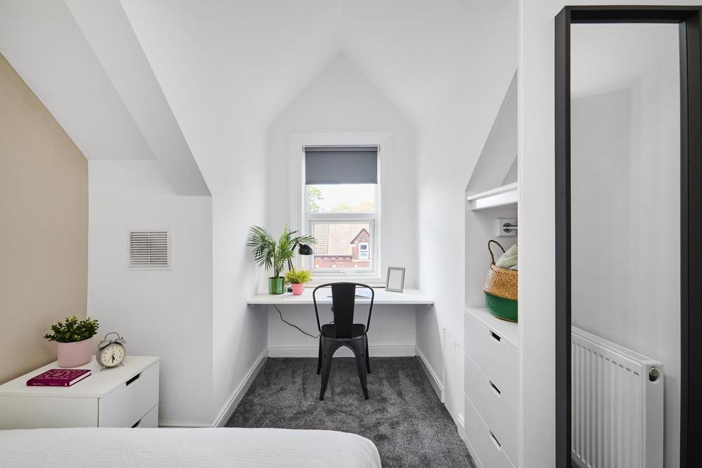 Bright, neatly styled bedroom with a built-in d...