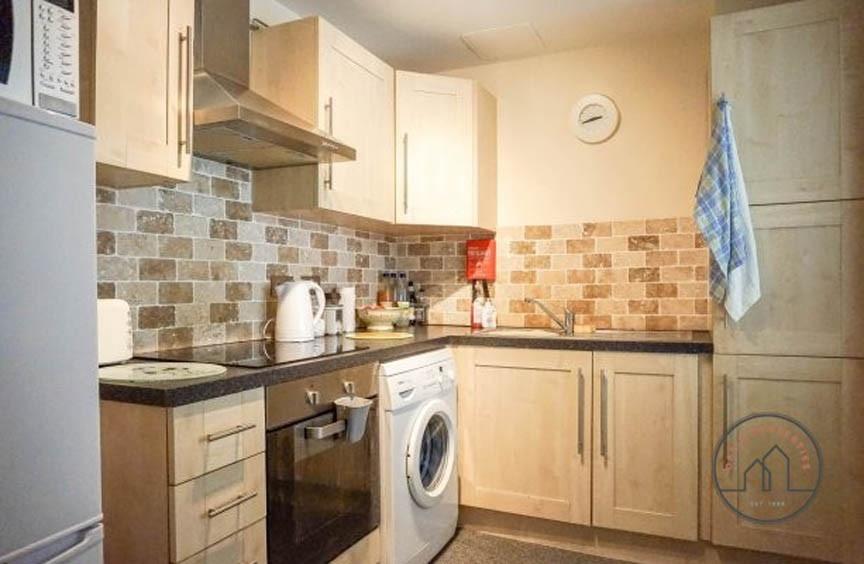 Bright, modern kitchen with integrated oven, ho...