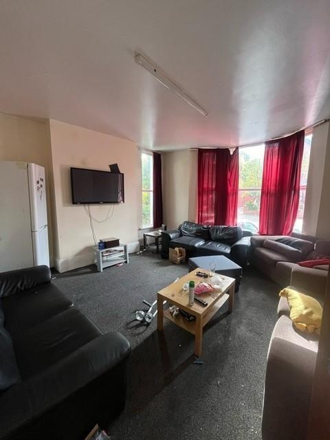 Spacious communal lounge with multiple sofas ar...