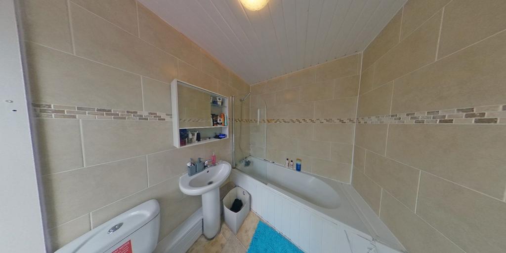 Bright, modern bathroom with tiled walls, a bat...