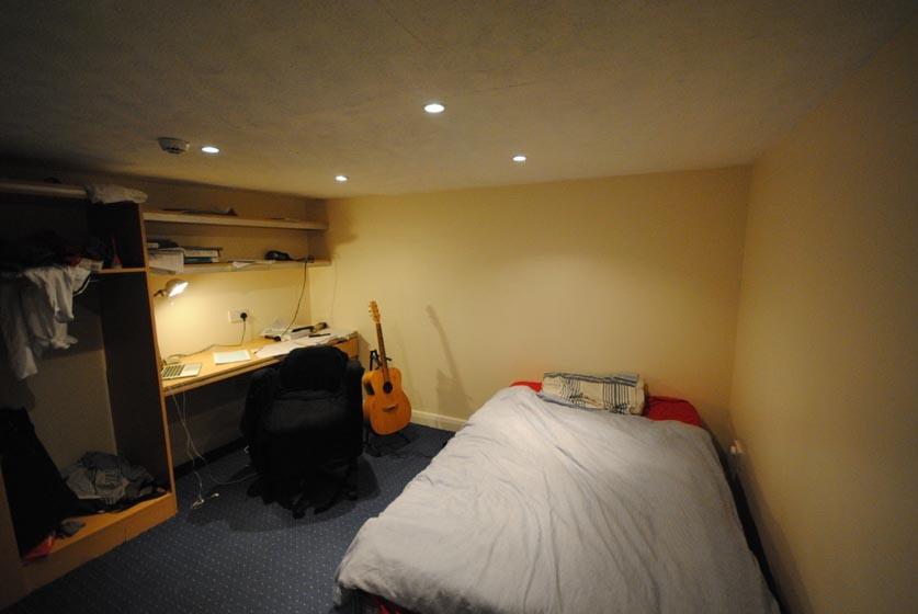 Cozy furnished bedroom with a single bed, built...