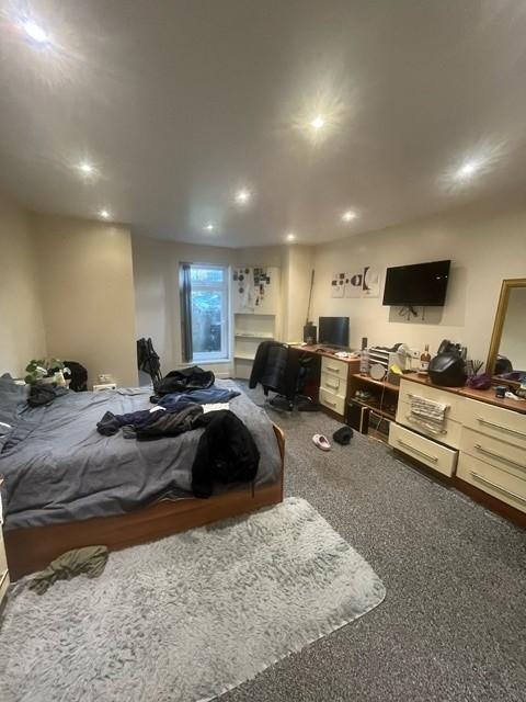 Well-lit, spacious bedroom with a double bed, l...