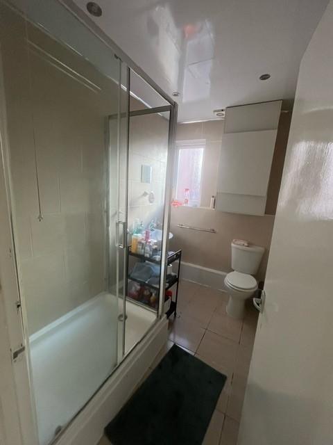 Bright, modern bathroom with a glass-enclosed s...