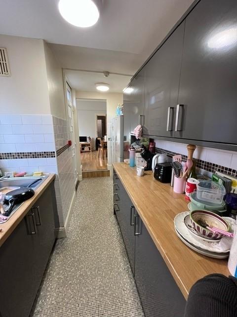 Long galley kitchen with grey fitted cabinets, ...