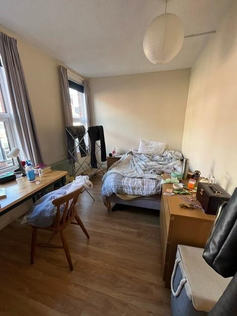 Bright bedroom with two front windows, a desk b...