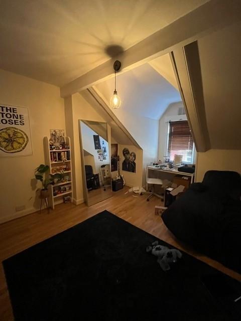 Cozy, well-styled bedroom with pitched ceilings...