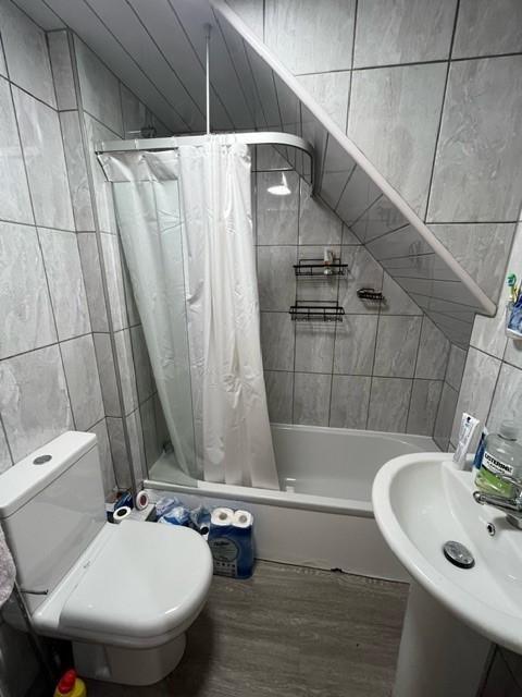 Bright tiled bathroom with a shower-over-bath, ...
