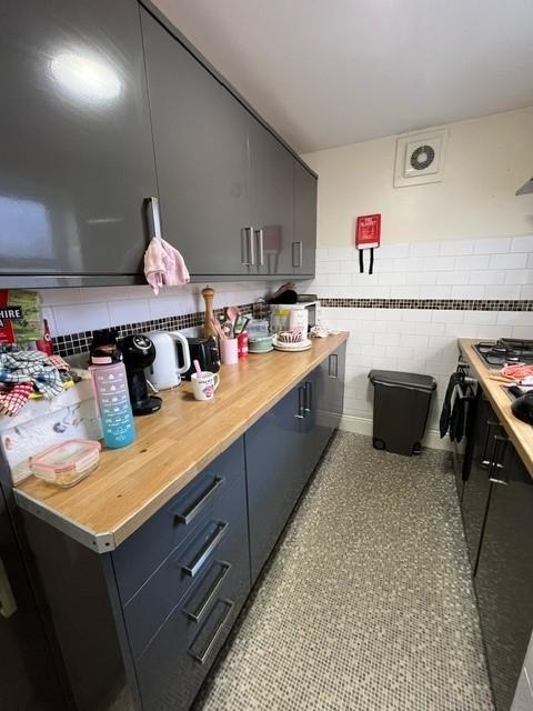 Modern galley kitchen with grey fitted cabinets...