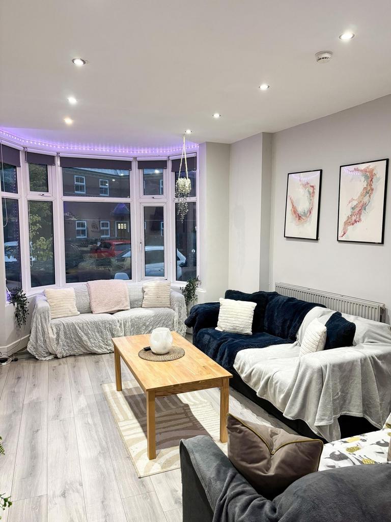 Bright, modern living room with a large bay win...