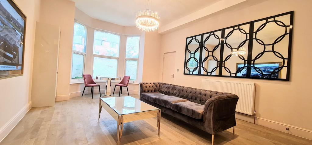 Spacious, well-lit living room with a large bay...