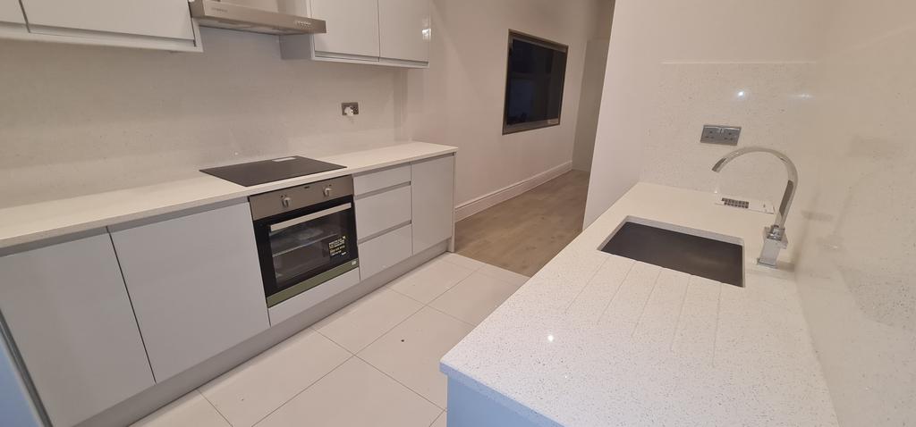 Bright modern kitchen with white cabinetry, int...