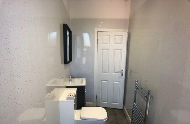 Modern white bathroom with a fitted vanity and ...
