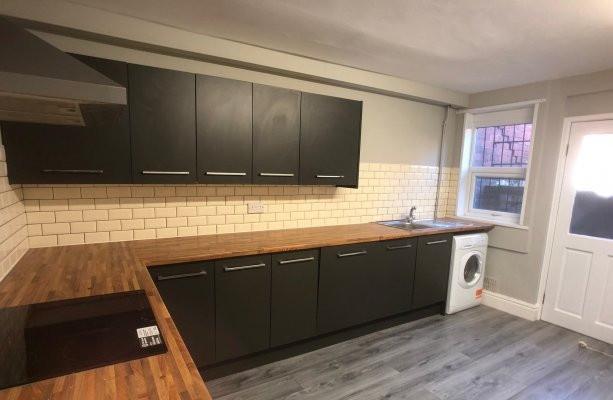 Bright fitted kitchen with long wooden worktops...