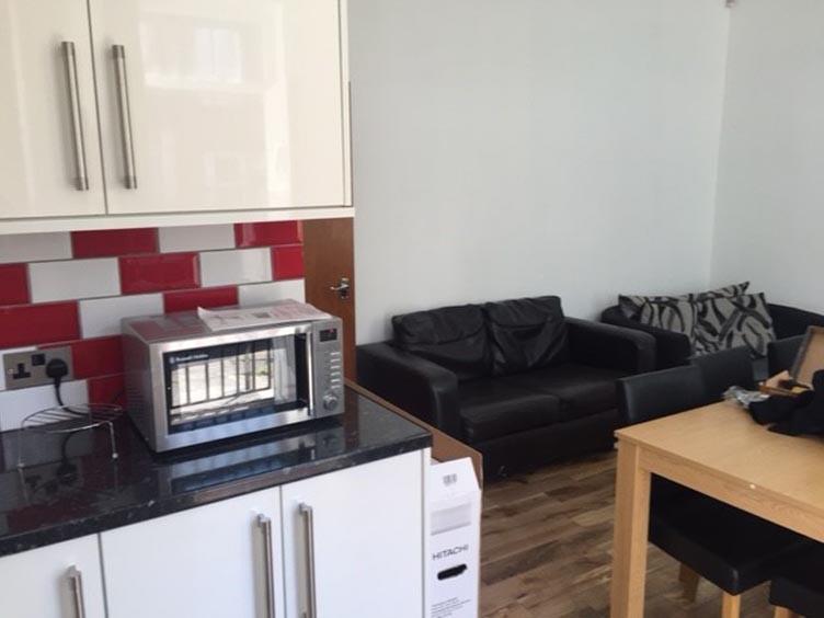 Bright compact kitchen area with modern white c...
