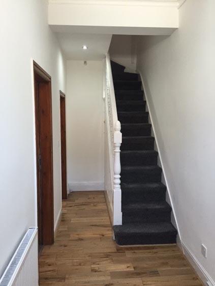 Bright, simple hallway with wood-effect floorin...