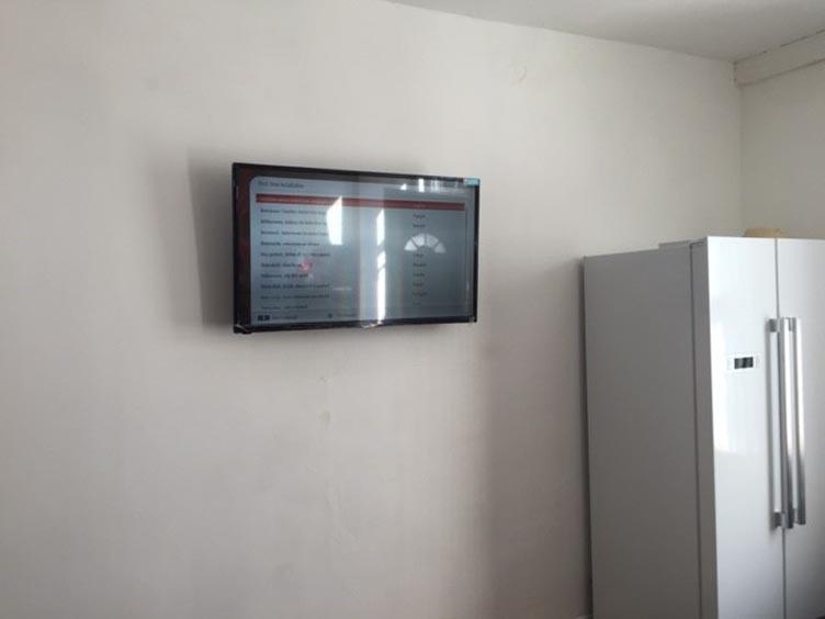 Simple kitchen area with a wall-mounted flat-sc...