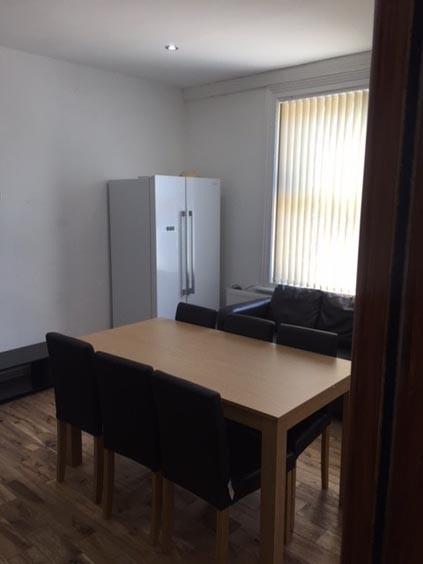 Bright communal living area with a wooden dinin...