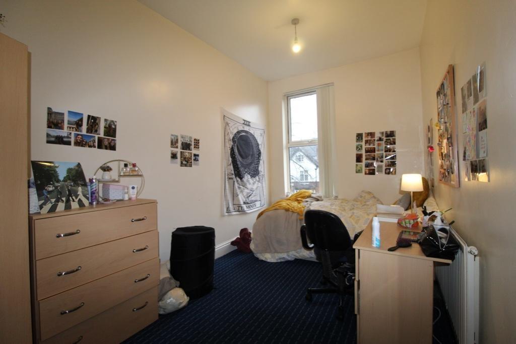 A cozy furnished bedroom with a single bed, des...