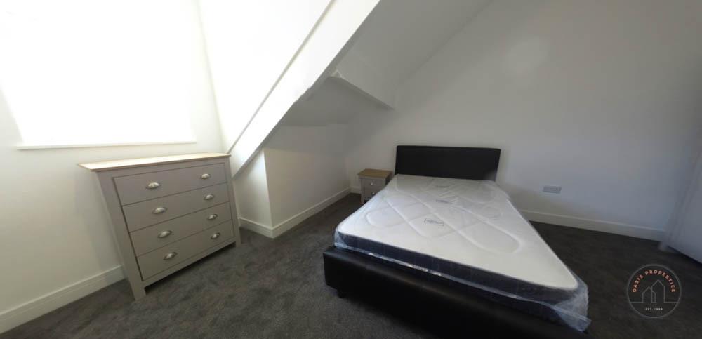 Bright attic bedroom with a sloped ceiling, lar...