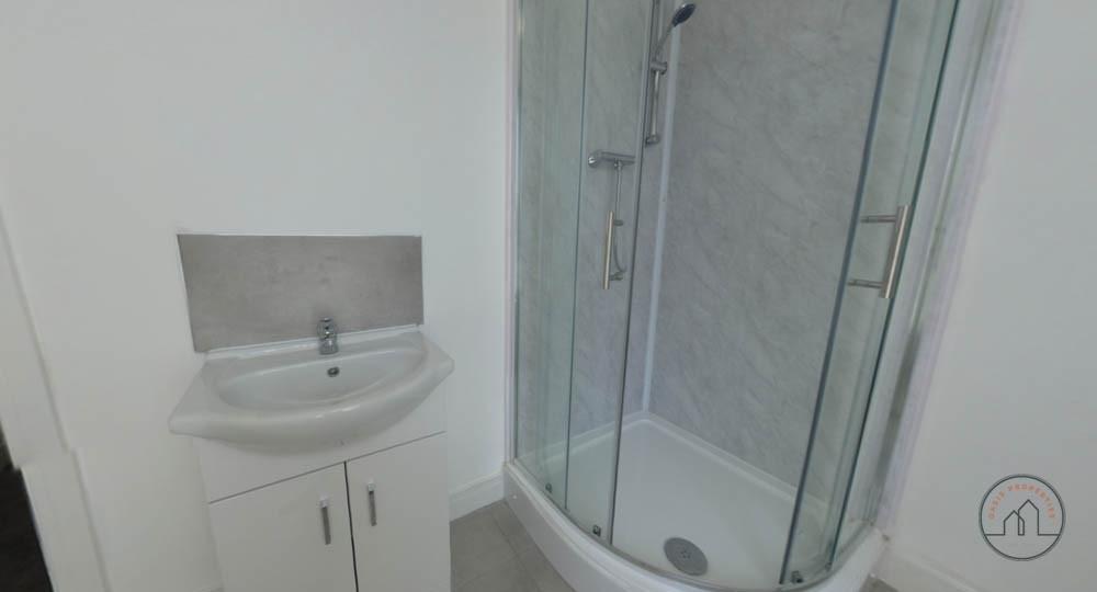 Bright, modern bathroom with a corner glass sho...