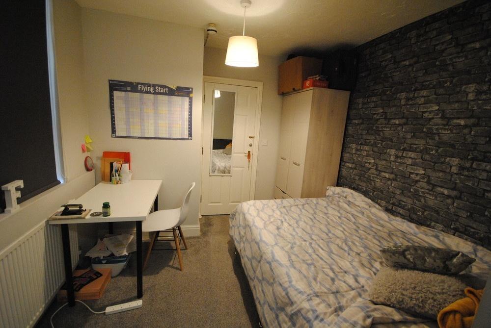 Bright, neatly arranged bedroom with a comforta...