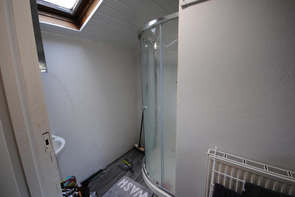 Compact bathroom with a corner glass shower, sk...