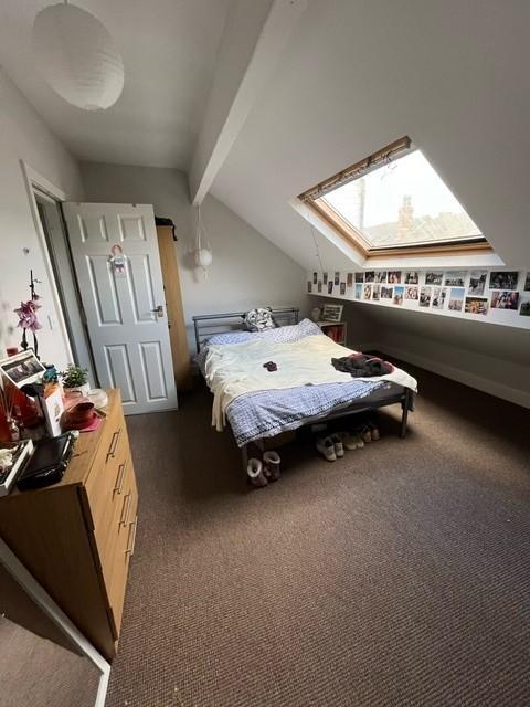 Bright attic-style double bedroom with a skylig...