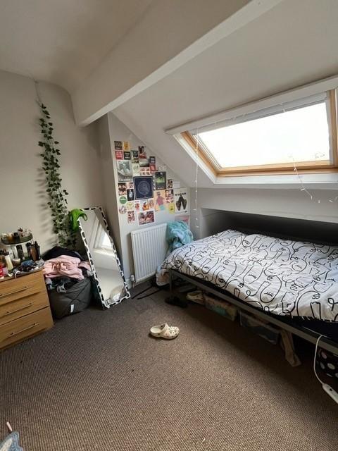 Bright attic double bedroom with a skylight, a ...