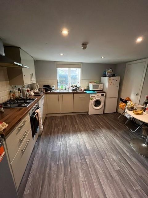 Modern fitted kitchen with light cabinetry, int...