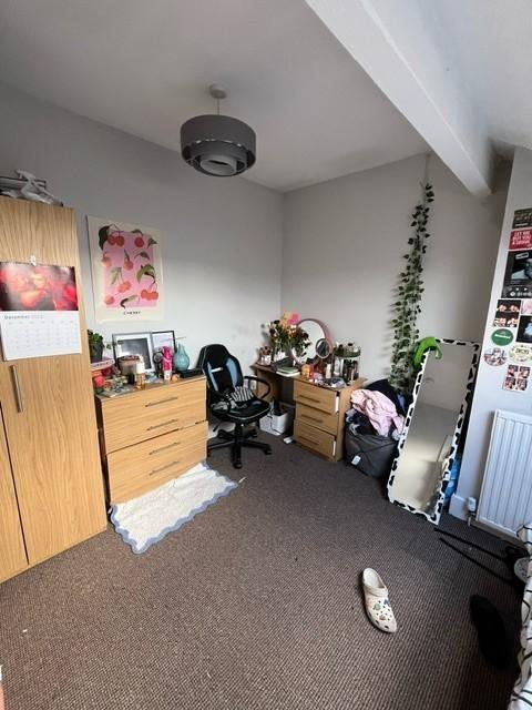 Bright bedroom with neutral walls, fitted stora...