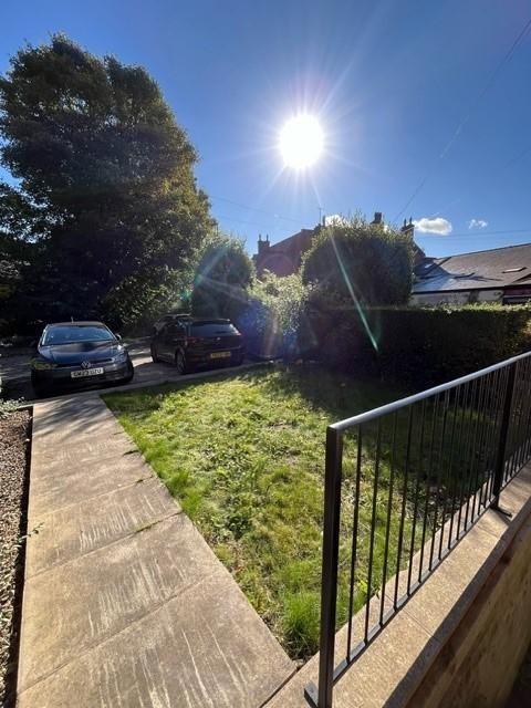 Sunny front garden and driveway with parking sp...