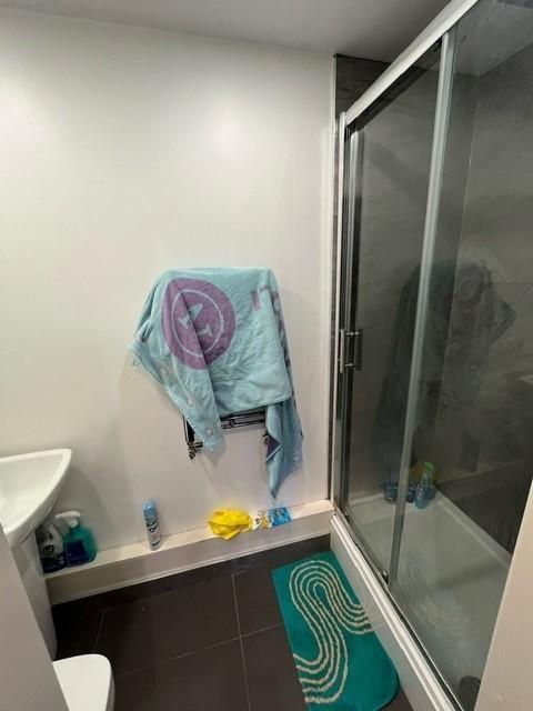 Compact modern bathroom featuring a glass-enclo...