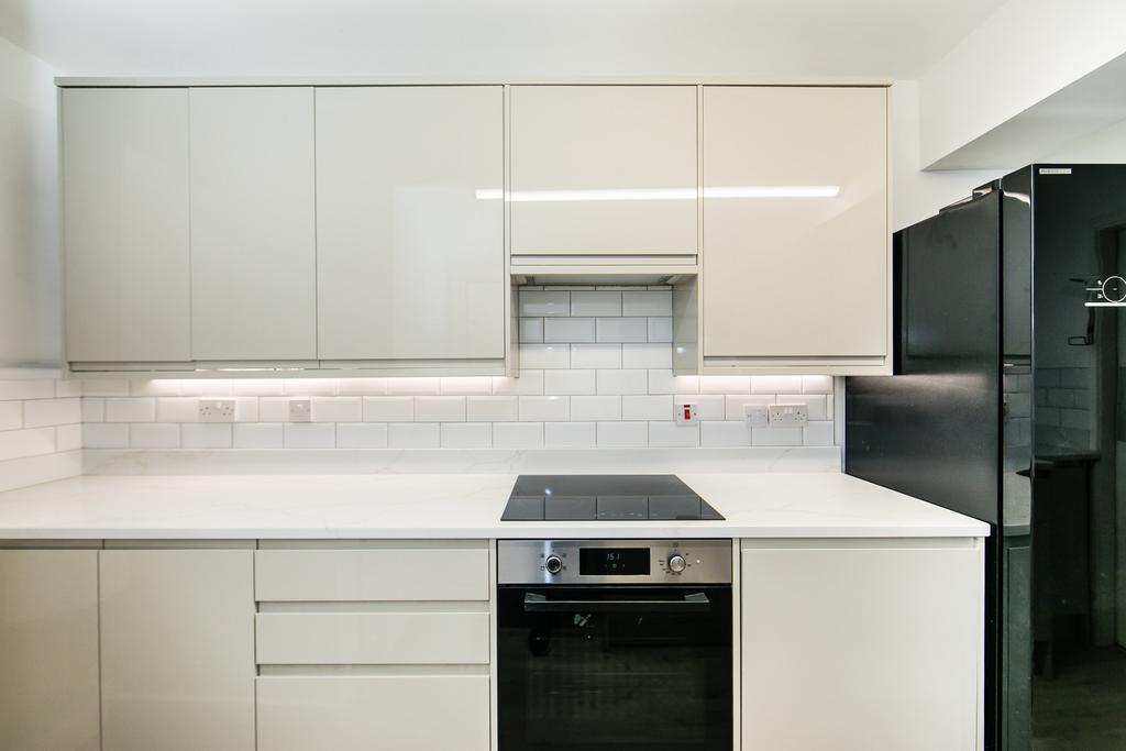 Bright modern kitchen with sleek white cabinetr...