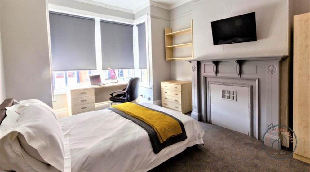 Bright, neatly presented bedroom with a bed, bu...