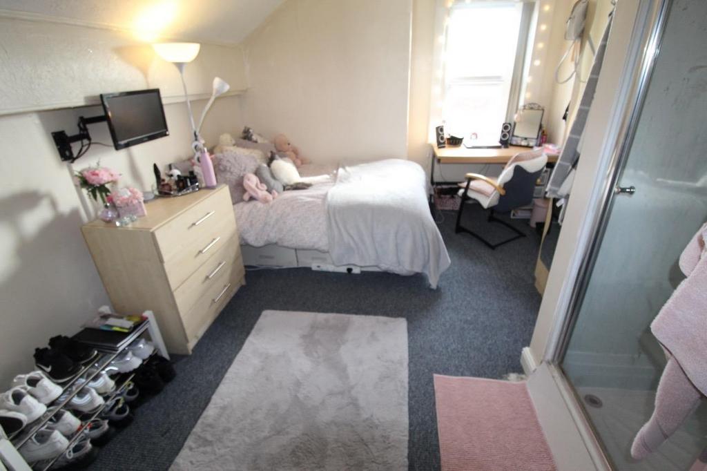 Bright, neatly kept bedroom with a comfortable ...