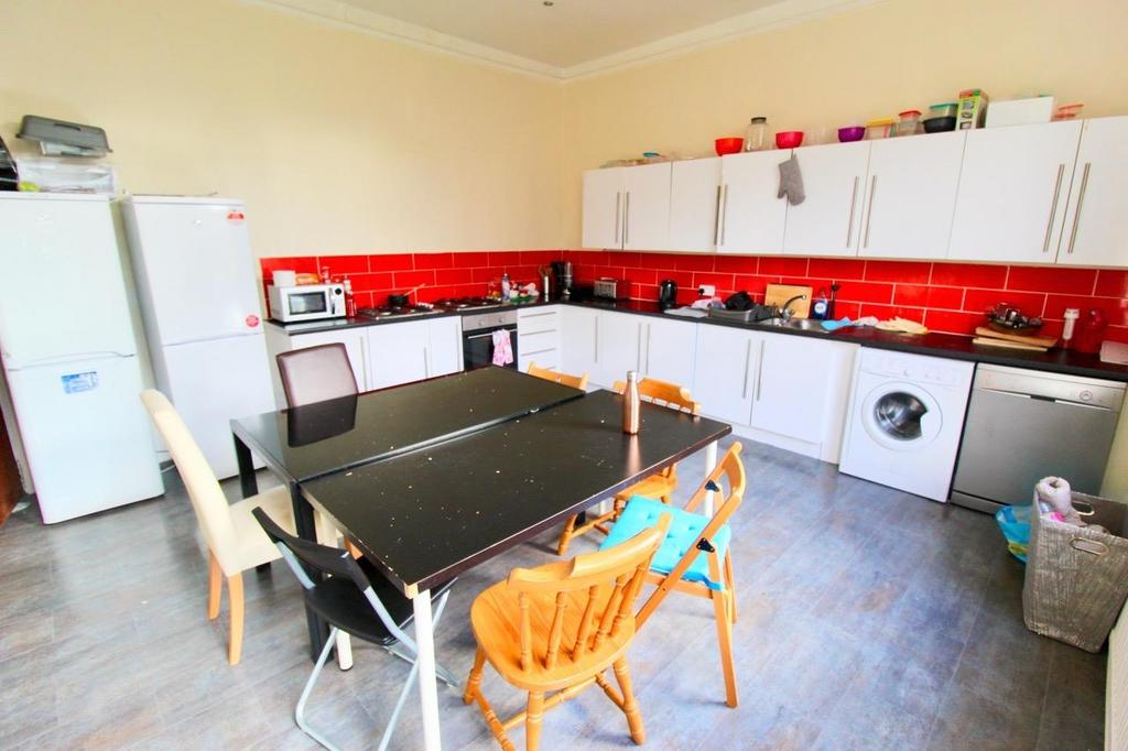 Bright, modern communal kitchen with white fitt...