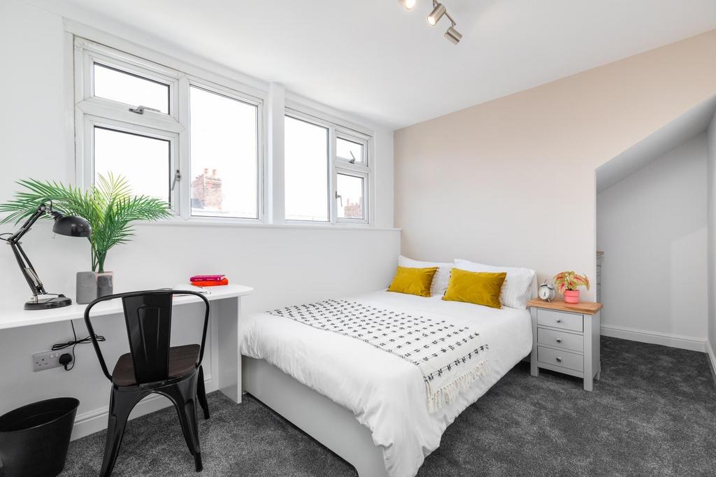 Bright, modern bedroom with a double bed, neutr...