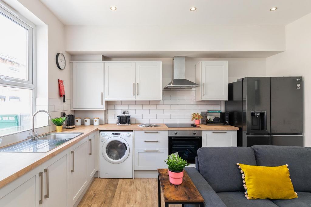 Bright open-plan kitchen with abundant storage,...