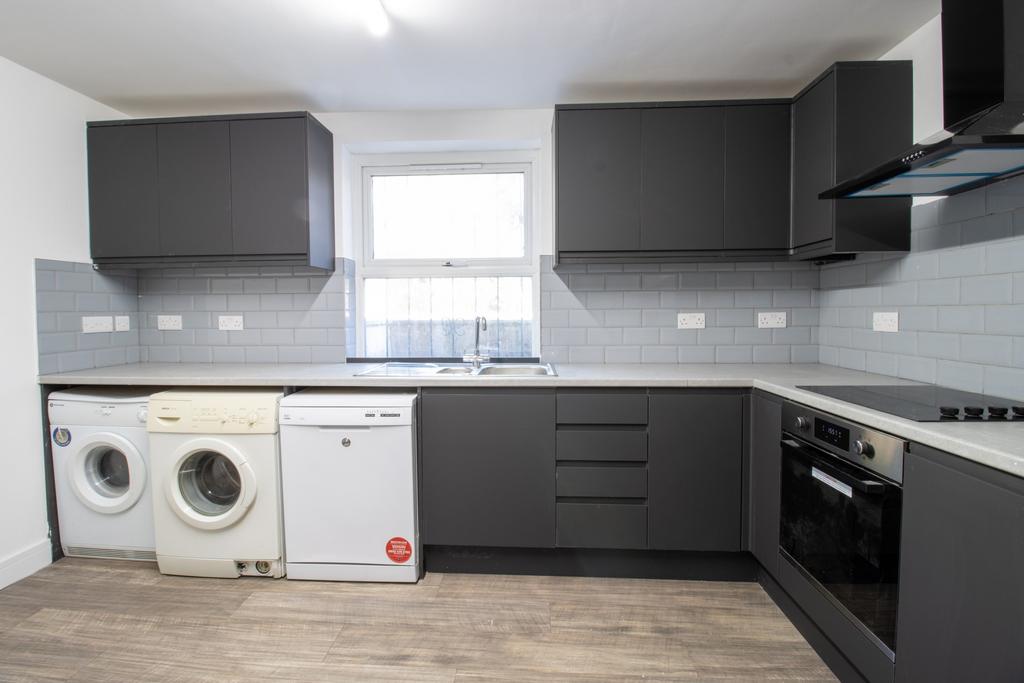 Modern fitted kitchen with dark grey cabinetry,...