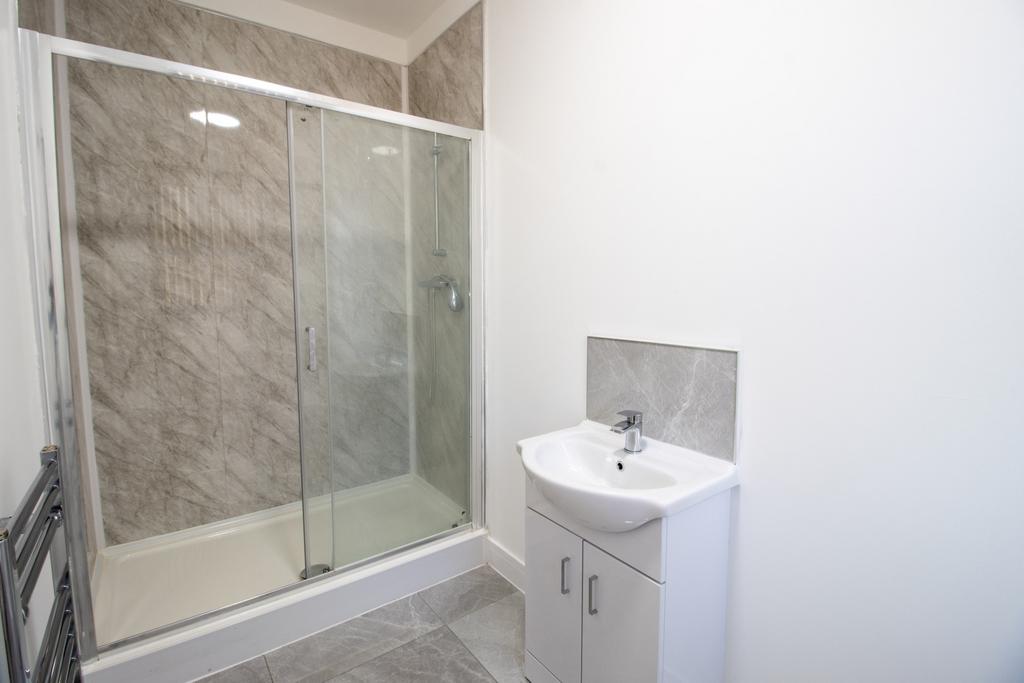 Bright, modern bathroom featuring a large glass...