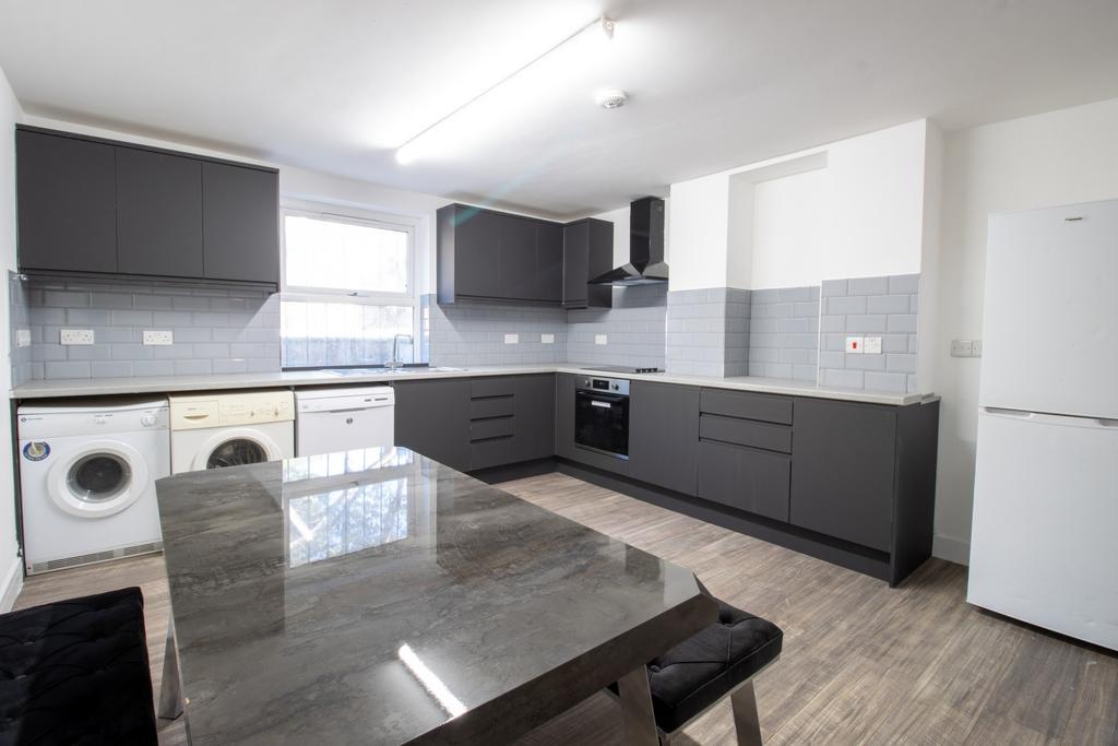 Modern open-plan kitchen with grey fitted units...